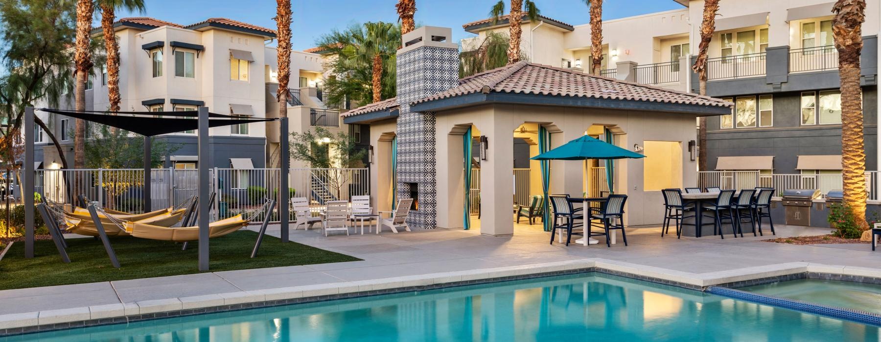 a swimming pool in front of a building with palm trees