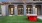 a building with a ping pong table and a large lawn in front of it